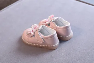Nahaufnahme rosa Prinzessinnenschuhe für Mädchen mit Perlenbogen und weicher Sohle.