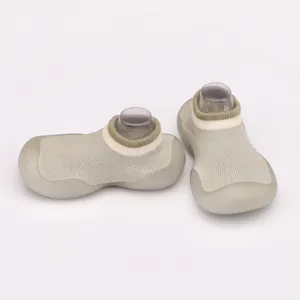 Close-up of breathable soft-sole baby pre-walker sock shoes in sage green knit finish.