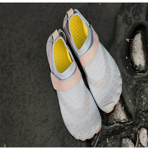 Top-down view of grey and orange breathable quick-dry outdoor water shoes on wet rocks