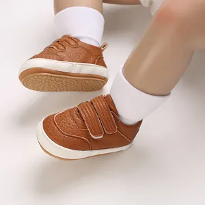 Primo piano di scarpe da ginnastica in pelle PU marrone per neonati con suola morbida.