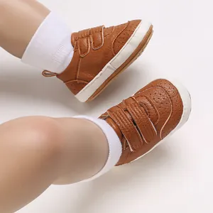 Dettaglio scarpe primi passi neonato in pelle PU marrone con chiusura a strappo