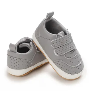 Graue Baby-Lauflernschuhe aus PU-Leder mit weichen Sohlen und Klettverschluss.