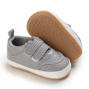Nahaufnahme grauer Babyschuhe mit weichen rutschfesten Gummisohlen und praktischem Klettverschluss