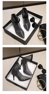 Close-up of black rhinestone mesh high-heeled boots in a stylish luxury gift box setup