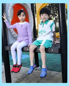 Two children wearing colorful non-slip water shoes for beach and outdoor fun activities