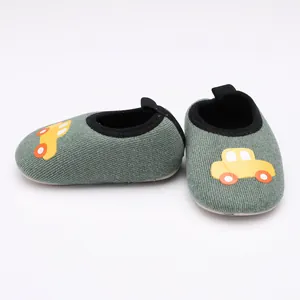 Vue détaillée de chaussures pour bébés avec motif de voiture jaune sur tissu gris