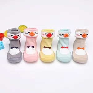 Une rangée de cinq chaussures chaussettes bébé pingouin colorées avec des semelles souples.
