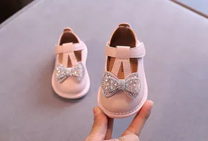 Nahaufnahme eleganter rosa Babyschuhe für Mädchen mit funkelnder Strass-Schleife