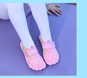 Close-up of pink children's water shoes with silver geometric patterns on a purple mat