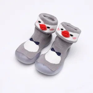 Détail de chaussures chaussettes pour bébé avec motif pingouin et semelles grises
