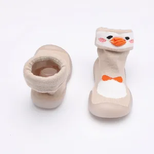 Gros plan sur les chaussures de marche pour bébé en forme de pingouin avec semelle souple