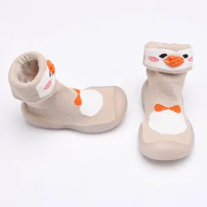 Détail de chaussures chaussettes pour bébé avec semelle souple et motif d'oiseau tricoté