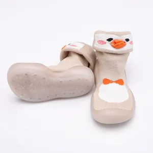 Gros plan de chaussures chaussettes bébé avec semelles souples et motif pingouin mignon.