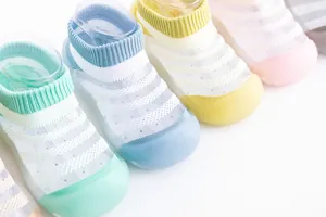Detail von atmungsaktiven Mesh-Babysocken-Schuhen in verschiedenen Pastellfarben mit Gummisohle.