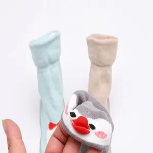 Détail d'un motif de pingouin mignon sur des chaussures chaussettes souples pour bébé
