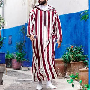 Vista dettagliata di una veste caftano da uomo a righe con cappuccio all'aperto.