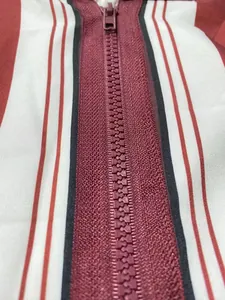 Primo piano della cerniera bordeaux su una vestaglia da uomo a righe con cappuccio.