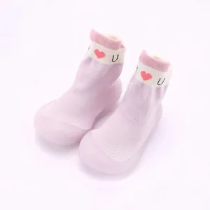 Detailansicht der weichen rosa Baby-Söckchenschuhe mit gestricktem Herzmuster.