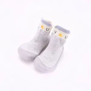 Detailansicht der hellgrauen Babysocken-Schuhe mit Sternenmuster und Gummisohle.