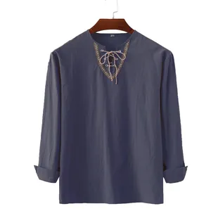 Detail view of men's cotton linen shirt with lace-up neckline and embroidered trim