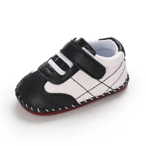 Dettaglio di scarpe da ginnastica in PU per neonati con contrasto bianco e nero e suola