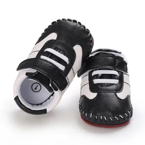 Dettaglio delle scarpe da passeggio per neonati in bianco e nero con suole rosse antiscivolo