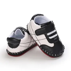 Dettaglio scarpe da camminata per neonati in PU bianco e nero con suola in gomma antiscivolo