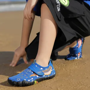 Quick-dry blue children's water shoes with circuit patterns shown on a sunny sandy beach