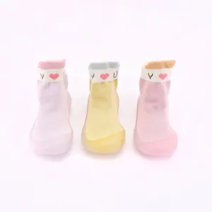 Detailansicht der gestrickten Baby-Lauflernschuhe in Pastellrosa, Gelb und Violett