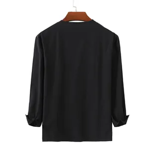 Detail view of the back of a loose black cotton linen long sleeve shirt for men