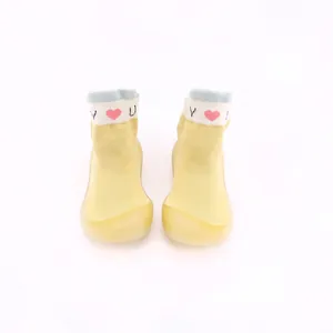 Gelbe Strick-Babyschuhe mit weicher Gummisohle und Herzmuster in der Detailansicht
