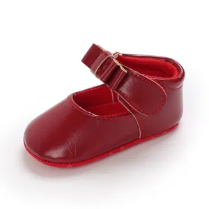 Detail shot of a red faux leather baby girl princess shoe with bow and soft sole
