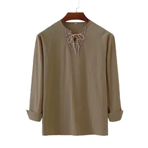 Detail of khaki cotton linen shirt with embroidered lace-up neckline and drawstring.