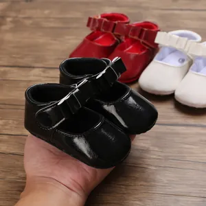Detailed macro view of black shiny infant girl princess shoes with cute bow magic tape strap