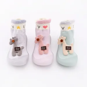 Close-up of cute cartoon baby sock shoes with knitted giraffe and soft rubber soles