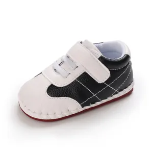 Primo piano di scarpe da ginnastica per neonati in PU bianco e nero con suola in gomma