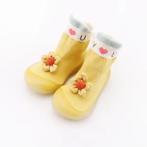 Macro detail of yellow baby sock shoes with cute 3D flower and a soft yellow rubber sole