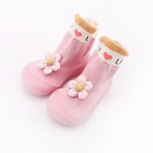 Detailed view of pink toddler sock shoes with decorative flower and soft rubber sole