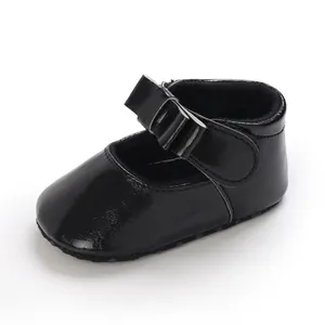 Close-up of black baby girl princess shoe with cute bow detail and soft leather material.