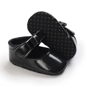Detailed view of black patent leather baby girl shoes with anti-slip soles