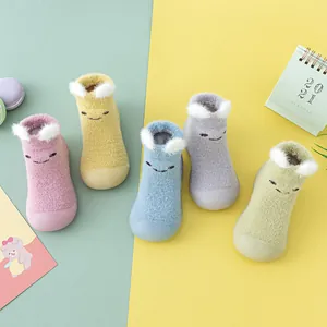 Nahaufnahme von bunten Baby-Hausschuhen mit 3D-Ohren und niedlichen Cartoon-Gesichtern.