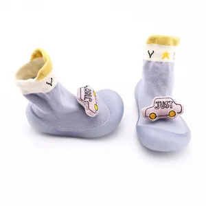 Detailed view of baby sock shoes featuring a cute pink cartoon car and soft blue knit