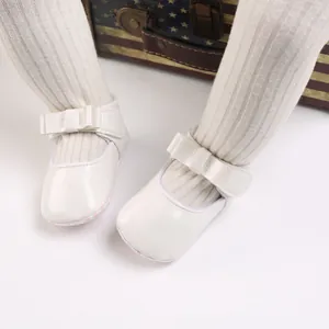 Elegant white baby princess shoes with large bow and soft patent leather finish