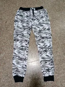 Full view of men's gray camouflage joggers with black drawstring and elastic cuffs on floor.