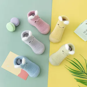 Draufsicht auf bunte Baby-Lauflernschuhe aus Nerzfell mit 3D-Ohren und Gesichtern