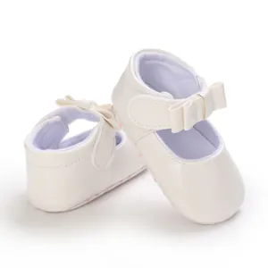 Detailed shot of white baby Mary Jane princess shoes with elegant bow decoration