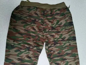 Detailed macro view of woodland camouflage print on men's casual joggers with elastic waist.