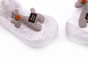 Close-up detail of cute cartoon animal doll on baby walker shoes with rubber soles