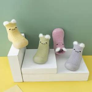 Detailansicht von vier Paar plüschigen Cartoon-Babyschuhen in verschiedenen Pastellfarben
