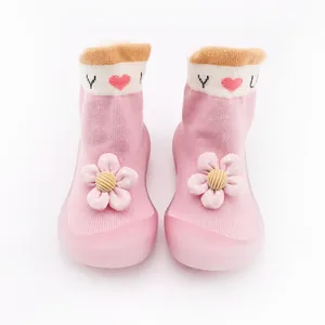Cute pink baby walking sock shoes with soft rubber sole and large decorative flower